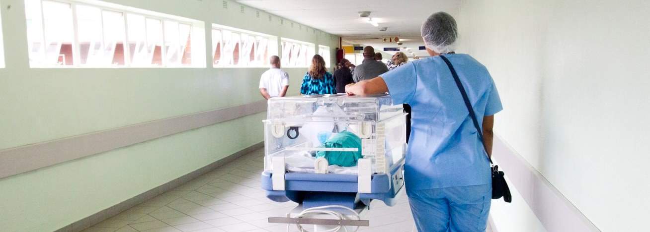 Nurse with baby in a medical hallway