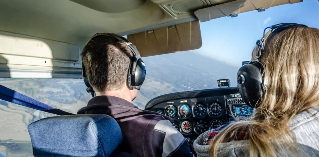 A man and a woman flying a small plane