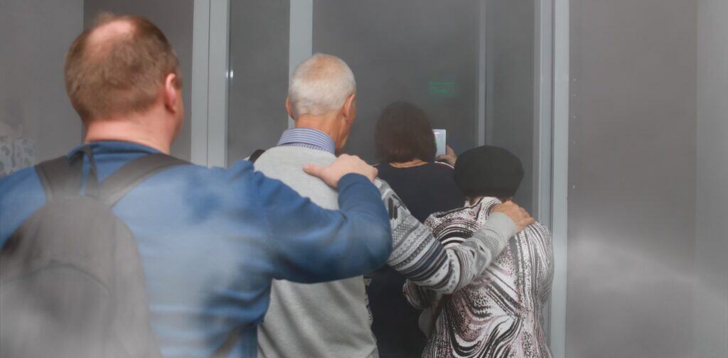 People evacuate a burning building one-at-a-time
