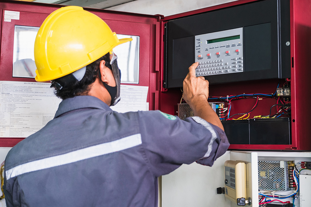 Man inspecting fire alarm panel