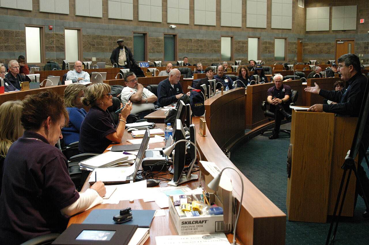 Emergency management personnel seated at workstations during an all-hands briefing in the Nevada state emergency operations center